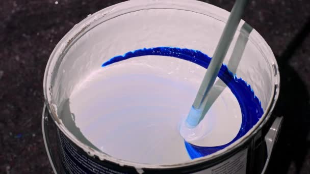 Le processus de mélange de la peinture bleue dans un seau avec un mélangeur. Mélange de peinture dans un tonneau, mélange de peinture dans une usine, mélange automatique des couleurs de l'usine. Mélange de peinture bleue dans une usine. 4K FOOTAGE. Gros plan — Video