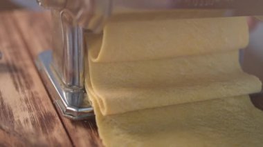 Hamur kesmek için geleneksel İtalyan yapımı makarna. Makarna makinesinden çıkan makarnadan yavaş çekim görüntüsü.