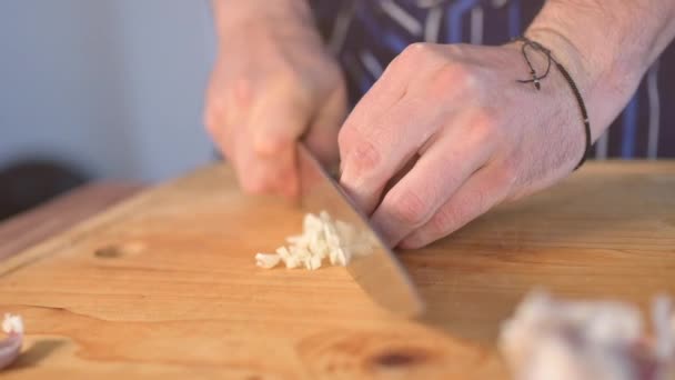 台所で調理中にニンニクをスライスシェフの手のスローモーション — ストック動画