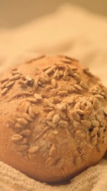 Köy arka planında ev yapımı ekmeğin dikey yakın çekim ağır çekim videosu. Taze fırın. Yeni fırınlanmış ekmek