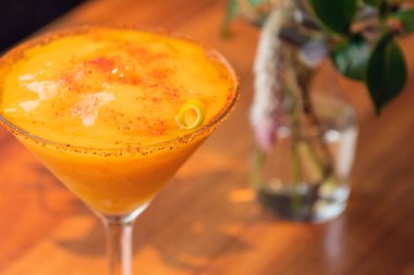 Ahşap masada mango margarita frappe, güneşli hava. Yazın Daisy.