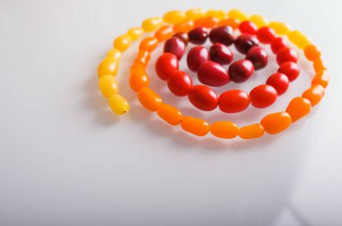 Beyaz arka planda çeşitli renkli domateslerin yaratıcı fotoğraf tasarımı. Renkli domateslerin üst görüntüsü, düz uzanmış..