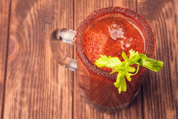 Michelada birası ve domates suyu. Tahta masada biralı Clamato. Meksika içkisi. Meksika yemeği.