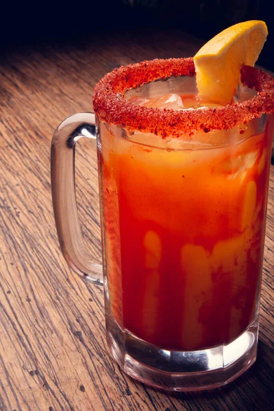 Michelada birası ve domates suyu. Tahta masada biralı Clamato. Meksika içkisi. Meksika yemeği.