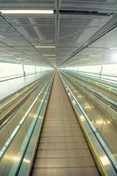 Coronavirus salgını ve askıya alınmış havayolu uçuşları nedeniyle boş havaalanı terminali. Boş havaalanı terminali. İnsansız mekanik koridor.