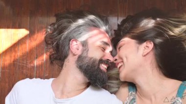 Aşık bir çift odalarında refleks yapıyor. Odalarındaki yataklarında birbirini seven bir çift. Genç çift gülümsüyor ve evde dinleniyor, yavaş çekim videosu.