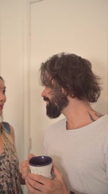 Bir çift romantik bir anda oturma odasında yerde yatıyor, çift öpüşüyor. Odalarındaki yataklarında birbirini seven bir çift. Evde gülümseyen ve dinlenen genç çift, dikey yavaş çekim videosu