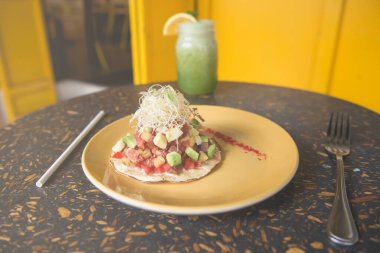 Ton balıklı Meksika tostu ve sarı tabakta mikrop tasarım masasında bir bardak yeşil meyve suyu. Sağlıklı gıda konsepti. Meksika sağlıklı yiyecekler