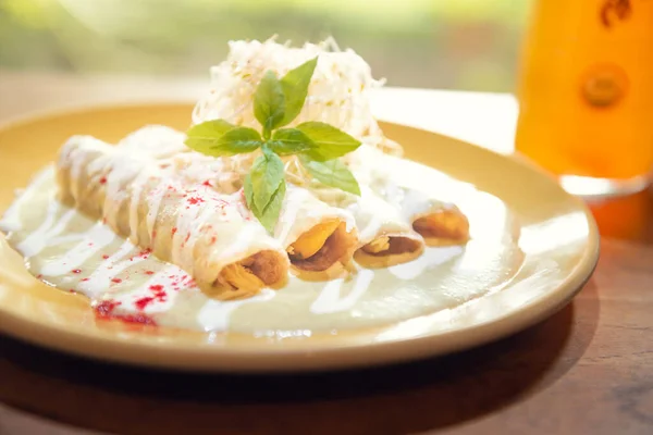 Geleneksel Meksika yeşil enchilada 'sı. Tipik Meksika kahvaltısı. Otantik Meksika enchilada 'sı kremalı yeşil sos ve erimiş peynir.