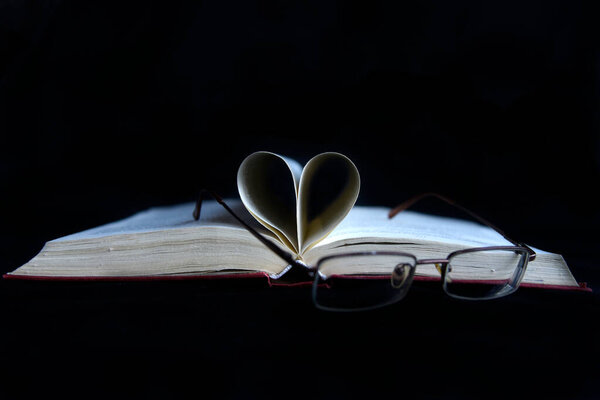 Open book on a black background.