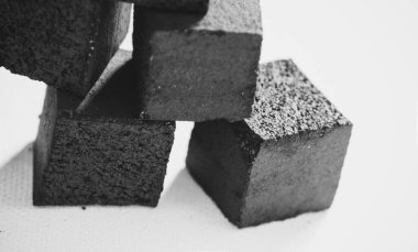 Bir nargile için hindistan cevizi kömürleri beyaz arka planda üst üste dururlar..