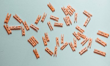 Beyaz arka planda bir sürü küçük tahta mandal var..