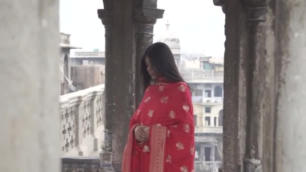 Een meisje in rode indiaanse traditionele kurti staan op het dak — Stockvideo