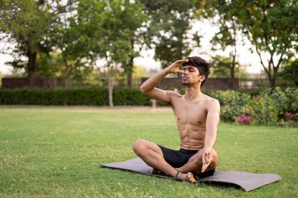 Uluslararası yoga gününde parkta yoga yapan, doğranmış genç bir Hintli çocuk, Anulom Vilom Aasan..