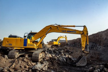 Mumbai, Maharastra, Hindistan - 22 Mayıs 2020: Mumbai yakınlarındaki bir madende çalışan iki JCB vinç