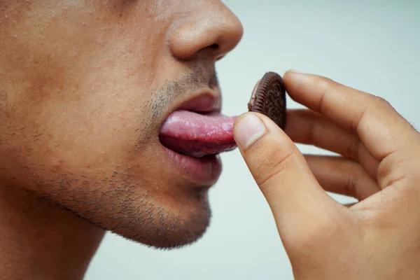 Close Man Licking Chocolate Biscuits Stock Picture