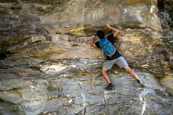 Νεαρό Αγόρι Σκαρφαλώνει Στα Βράχια Φορώντας Σακίδιο — Φωτογραφία Αρχείου