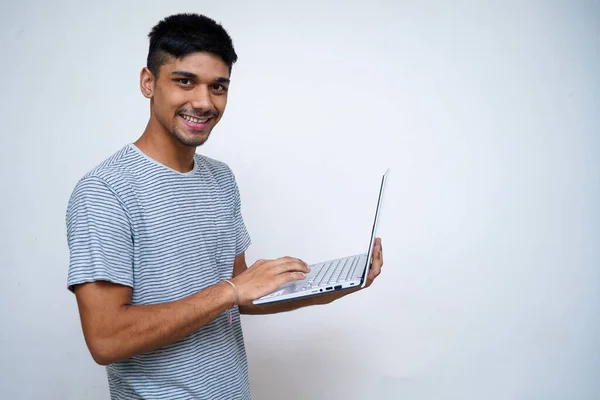 Junger Indischer Gutaussehender Junge Lächelt Die Kamera Während Seinen Laptop — Stockfoto