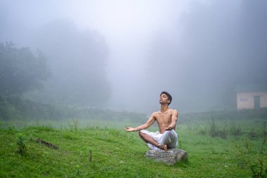 Dağlarda meditasyon ve zen enerjisi yogası yapan bir adam. Sabahları dışarıda spor yapan bir adam. Sağlıklı yaşam tarzı kavramı
