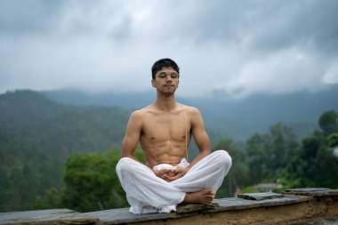 Dağlarda meditasyon ve zen enerjisi yogası yapan bir adam. Sabahları dışarıda spor yapan bir adam. Sağlıklı yaşam tarzı kavramı