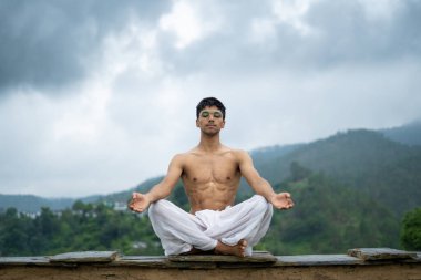 Dağlarda meditasyon ve zen enerjisi yogası yapan bir adam. Sabahları dışarıda spor yapan bir adam. Sağlıklı yaşam tarzı kavramı