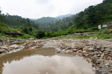 Arka planda bulanık dağlar olan yerde su birikintisi