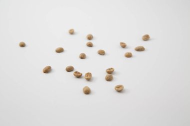 Beyaz zemin üzerinde izole edilmiş, fotokopi alanı olan çiğ kahve çekirdeklerini yakın çekim