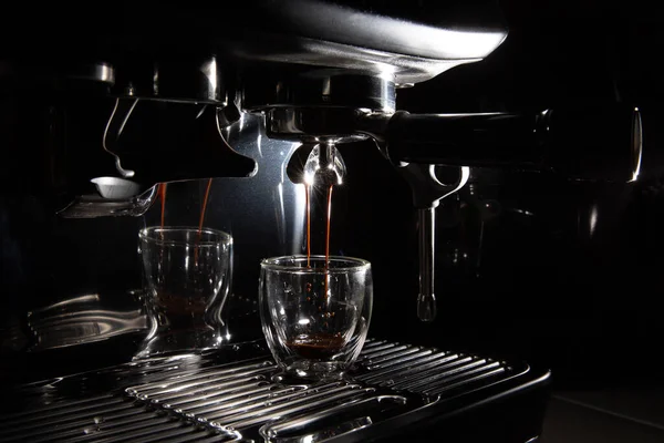 Koyu kahve damlaları şeffaf cam bir espresso bardağına damlıyor. Elle yapılan espresso makinesinde fotokopi alanı var.