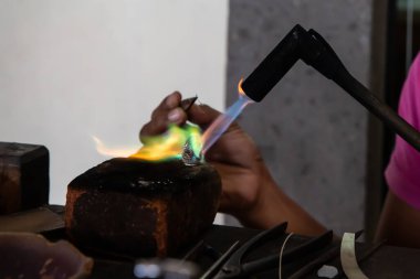 Balili bir kadın, Endonezya, Bali 'de meşale ile gümüş bir yüzük yapıyor.