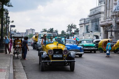 Havana / Küba - 04.15.2015: Ulusal Kongre Binası önünde sarı klasik bir taksiye binen turistler