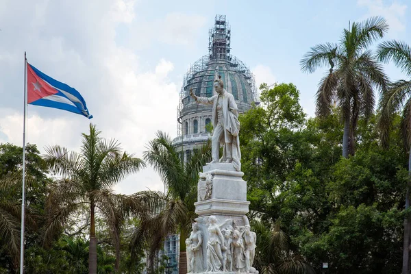 Havana / Küba - 04.15.2015: Ünlü şair Jose Marti 'nin elinde kuşlarla Küba bayrağına bakan beyaz mermer heykeli. Arkasında Capitol Binası var. Central Park (Park Merkezi), Havana.