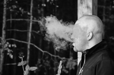 Bir adam nargile tüttürür ve çok fazla duman çıkarır..