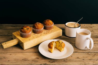 Kahve ve esmer şekerle birlikte tahtanın üzerinde çikolata parçacıkları olan çöreklerle dolu bir hayat.