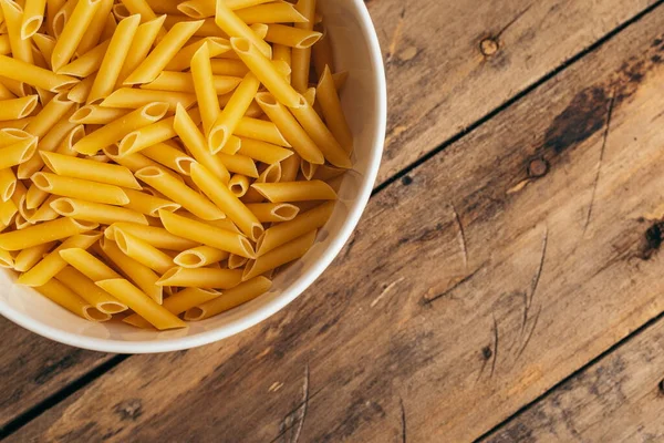 Eski ahşap bir masada makarna salatası için malzemeler.