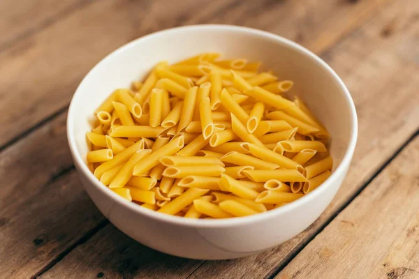 Eski ahşap bir masada makarna salatası için malzemeler.