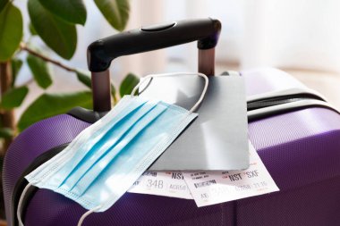 Avrupa, Asya 'ya yapılan uçak uçuşlarında zorunlu korona virüs maskesi kullanımına bağlı COVID-19 seyahat kısıtlaması. Pasaport, uçak bileti ve bavul tatil için hazır..