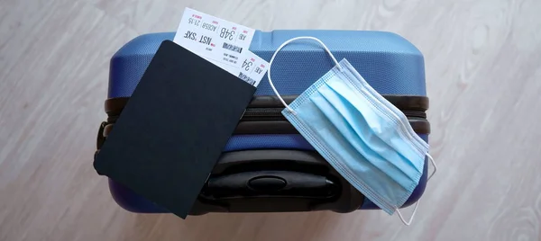 Avrupa, Asya 'ya yapılan uçak uçuşlarında zorunlu korona virüs maskesi kullanımına bağlı COVID-19 seyahat kısıtlaması. Pasaport, uçak bileti ve bavul tatil için hazır..