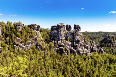 Bastei, Bastei Köprüsü manzaralı. Bastei, Dresden yakınlarındaki Sakson İsviçre Ulusal Parkı 'ndaki güzel kaya oluşumuyla ünlüdür. Saksonya 'da popüler seyahat noktası.