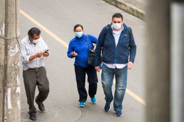 Maske takan yaşlı ve orta yaşlı kadın ve erkekler Bogota, Kolombiya sokaklarında yürüyorlar. Koronavirüsü kapmaktan ve yaymaktan kaçının.. 