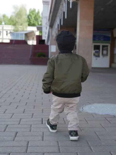 Küçük oğlan yalnız gidiyor. Arkadan bak. Bebek yalnız, ailesi yok.