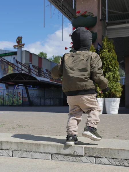 Küçük oğlan yalnız gidiyor. Arkadan bak. Bebek yalnız, ailesi yok.