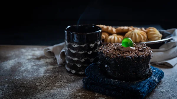 chocolate cake and a hot drink with cookies and a black background
