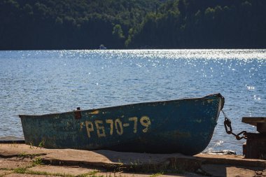 Nehir kıyısında bir güneşli yaz gününde eski teknede