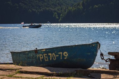 Nehir kıyısında bir güneşli yaz gününde eski teknede