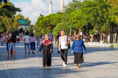 Istanbul, Türkiye - 21 Ağustos 2018: iki Müslüman kadın bir eşarp ve genç adam aşağı Sultan Ahmet Meydanı'nda yürüyor
