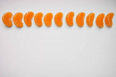 Dilim mandalina bölümlerini tek bir satırda beyaz arka plan üzerinde görev yaptı. Üstten görünüm, kopya alanı