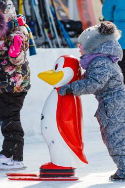 Pavlovsky Kayak Park, Rusya - 10 Mart 2018: bir penguen Skate yardımı ile pisti üzerinde küçük bir kız. Buz pateni öğrenmek için destek