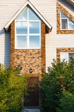 ağaçların arasından pencereli evin giriş