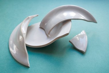 yeşil zemin üzerine kırık beyaz tabak yığını