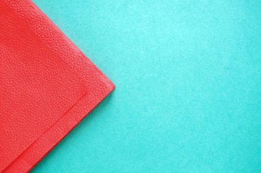 kartondan yapılmış mavi arka planda kırmızı kağıt peçete parçası, kopya alanı